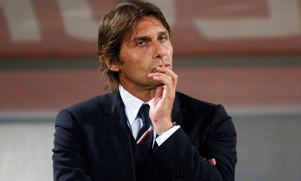 Picture of Antonio Conte in a suit standing pensively with his hand on his chin 